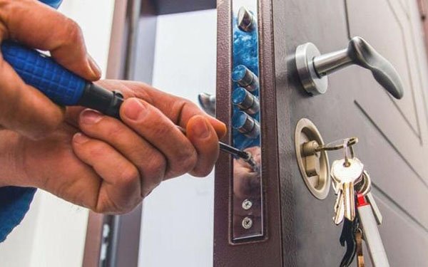 Técnico reparando una cerradura con destornillador