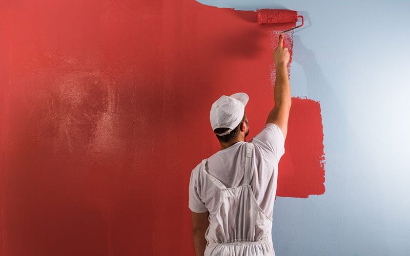 Trabajadores pintando una pared de color rojo